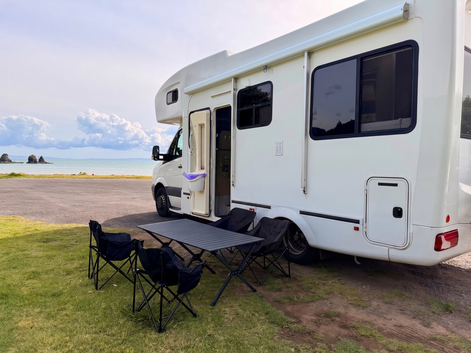 The real Hey Buddy motorhome set up beside the coast